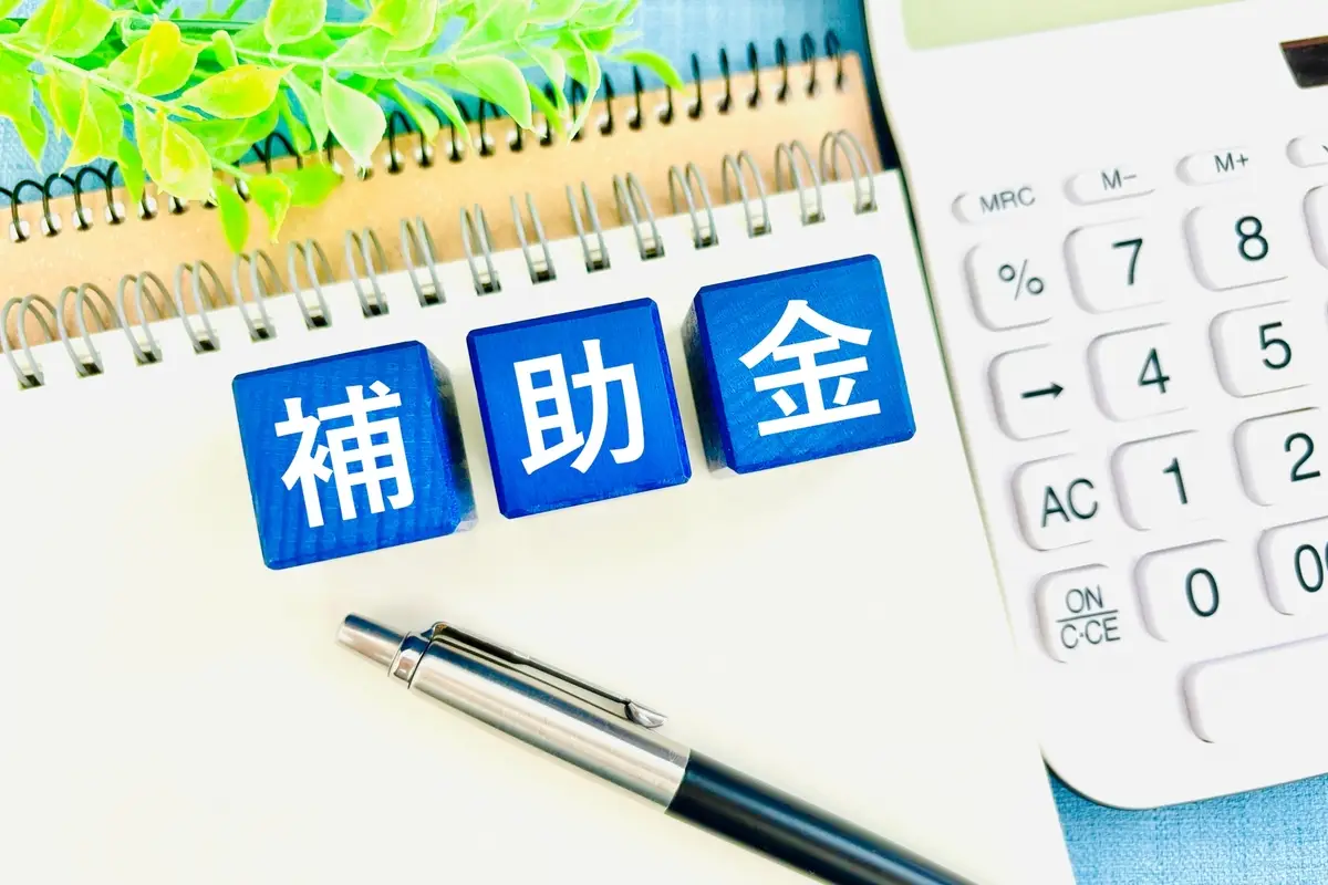補助金のブロックとノート、電卓