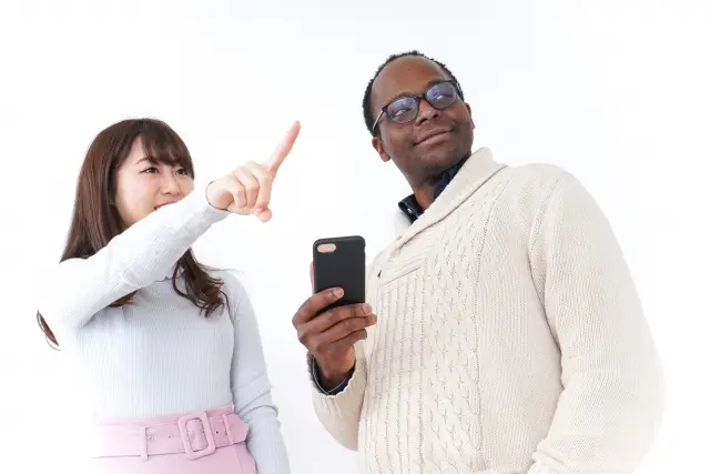 スマートフォンを見ながら話す外国人男性