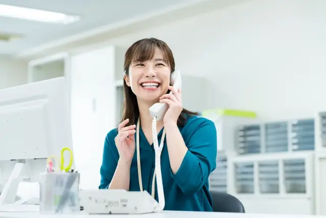 笑顔で電話を取る女性
