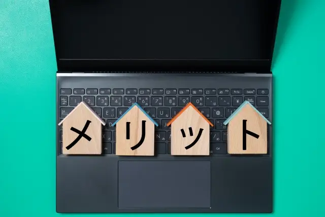 メリットと書かれたブロックとパソコン