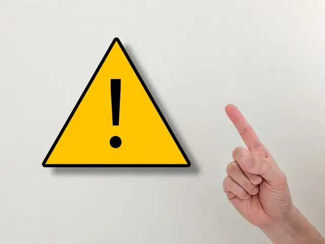 注意を示す黄色い看板と人差し指